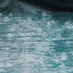 Heavy rain and rising flood water near homes illustrating flood insurance coverage