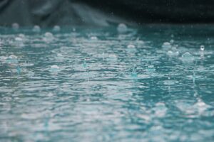 Heavy rain and rising flood water near homes illustrating flood insurance coverage