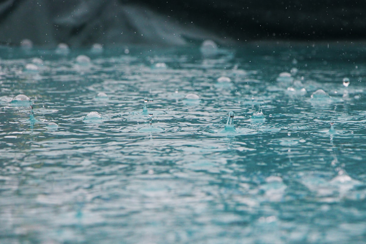 Heavy rain and rising flood water near homes illustrating flood insurance coverage